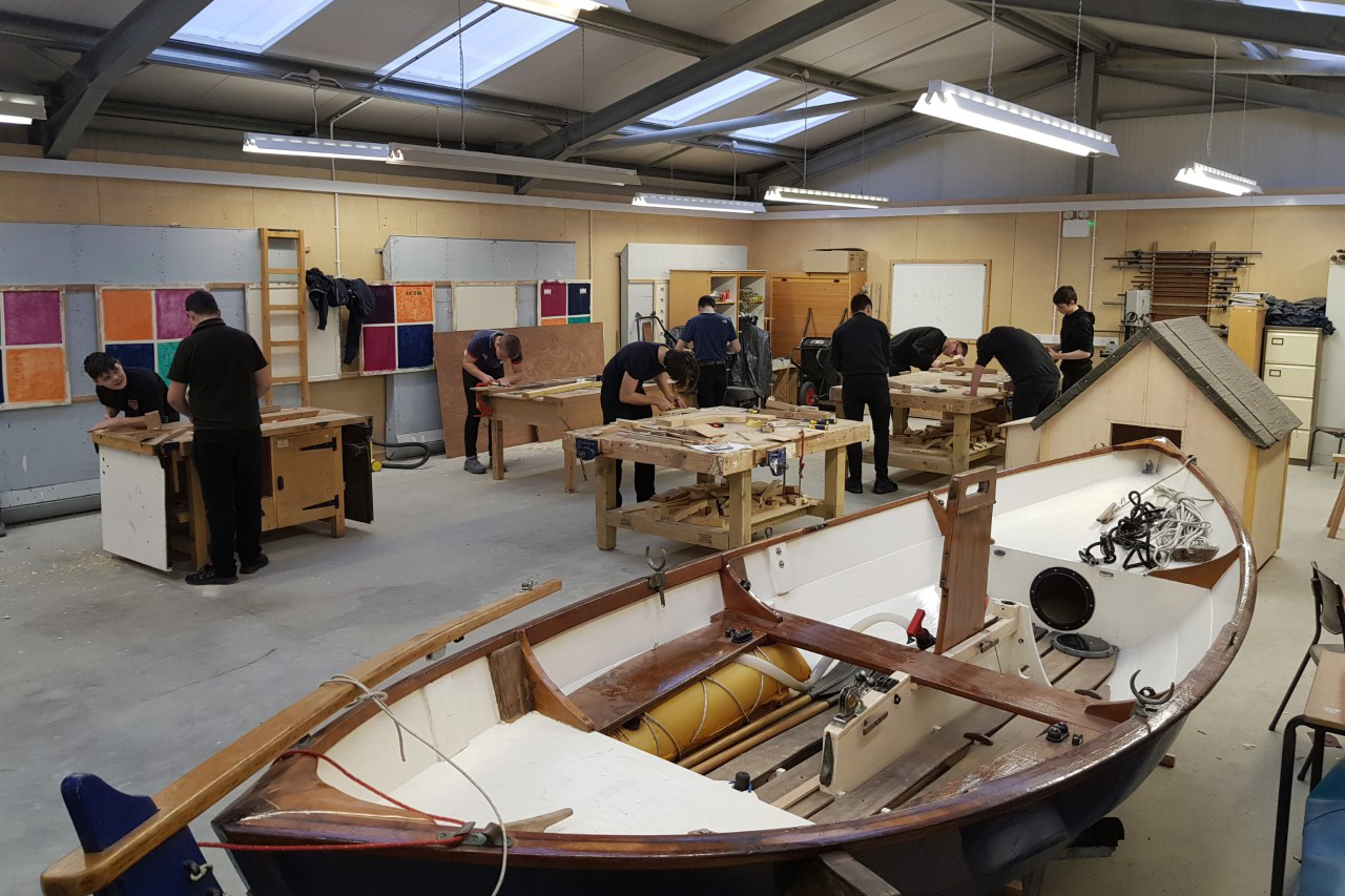 Boat builing students working in the school workshop.